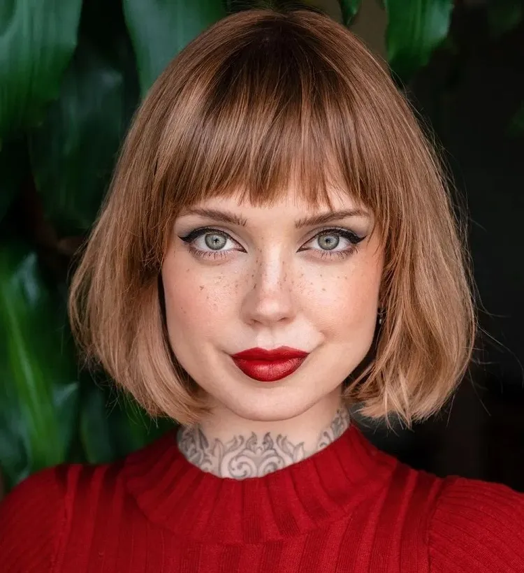 A brown fringe on beige-short blond hair superimposed to match the tattoos
